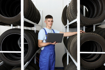 Sticker - Young man with laptop near car tires in auto store