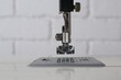 © New Africa - Modern sewing machine against white brick wall, closeup
