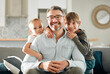 © peopleimages.com - Dad, kids and hug in home portrait, peace and single parent love for boys in living room. Father, children and embrace for security on couch for care in childhood, relationship and comfortable joy