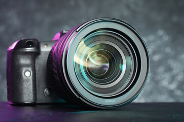 Poster - Modern photo camera on black table. Photographer's equipment