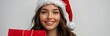 © olegganko - Woman Wearing Santa Hat Smiles for Christmas