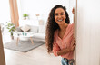 © Prostock-studio - Welcome. Portrait of cheerful woman standing in doorway of modern apartment, greeting visitor and inviting guest to enter her home, happy smiling young lady holding door looking out flat