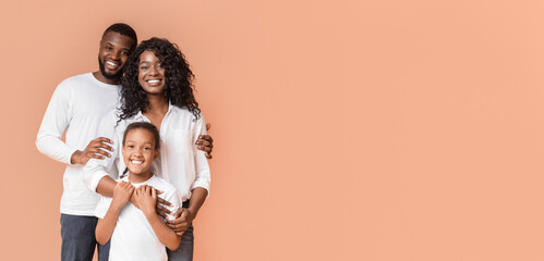 Wall Mural - Happy Family Of Three Hugging Posing Over Yellow Background In Studio