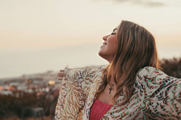 Wall Mural - Portrait of one young beautiful woman with opened arms smiling with closed eyes enjoying freedom sensation emotion. Teen cheerful face close up.