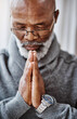 © peopleimages.com - Praying, hands and senior black man in house with peace, gratitude and grace, mercy or trust in God. Worship, spirituality and calm elderly African person with thank you prayer for Jesus Christ