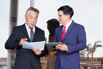 Wall Mural - Smiling businessman standing and talking in the office.