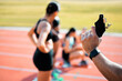 © Courtney/peopleimages.com - Hand, race and fire starter gun for running or exercise with athlete on track. Starting pistol, group or women at stadium field to get ready for training, cardio or sprint competition closeup outdoor