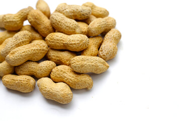 Wall Mural - Roasted peanuts in shell on white background.