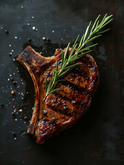 Canvas Print - Grilled bone-in steak garnished with rosemary on dark background