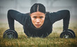 © DavisShared/peopleimages.com - Portrait, push ups and woman with dumbbells on grass for cardio workout, endurance challenge or muscle growth. Fitness, wellness and athlete on floor for performance, training or strength exercise