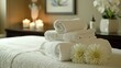 © Zeynep - A Couple of Folded Towels Sit on Top of a Massage Table With Two White Flowers - Generative AI
