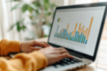 Poster - person analyzing colorful bar graphs on a laptop, working remotely in a bright, plant-filled home of