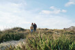 © Westend61 - Active senior man and woman walking amidst plants under cloudy sky