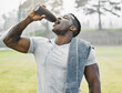 © Courtney/peopleimages.com - Black man, rest and drinking water outdoor for fitness, wellness and body health goals in morning. Male athlete, bottle and hydration with liquid and towel on field for workout, training or exercise