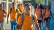 © Nick - Teenage in orange shirt with backpack going to school or back home with friends in background African American male boy look at camera
