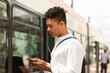© Westend61 - Man using smart phone and waiting for bus at street