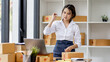 © David - SME concept. Young asian female ecommerce business owner prepares package box for customer and delivery check balance.  SME small business entrepreneur SME or freelance