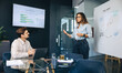 © Jacob Lund - Business woman delivering a marketing presentation to her partner and colleague in an office