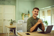 © bnenin - A smiling man with a mustache, posing for the camera while working in the co-working space.