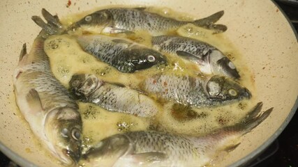 Wall Mural - the process of frying several goldfish at once using a frying pan