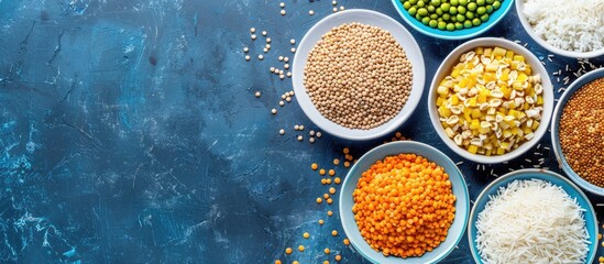 Leinwandbilder - Various cereals like buckwheat lentils rice and peas presented on plates with a blue background in a top view shot creating a composition with room for additional elements copy space image