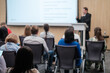© Anton Gvozdikov - Business professional giving presentation to attentive audience in modern conference room