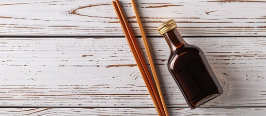 Fototapete - Chopsticks resting on a white wooden table beside a bottle of soy sauce creating a serene setting for a copy space image