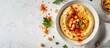 © Gular - Text space available for caption on a flat lay with a tasty hummus dish featuring chickpeas and paprika on a white table. copy space available