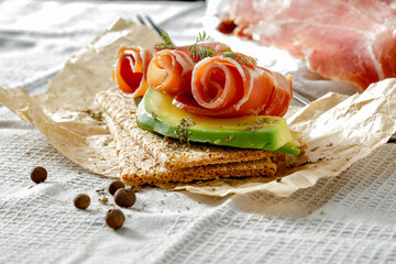 Wall Mural - Sandwiches with crispbread and cold cuts of black forest ham Schwarzwälder Schinken on a kitchen table with gray tablecloth. Copy space for food and drink and products. Delicious nutritious breakfast 