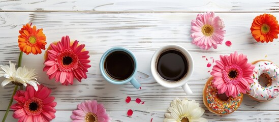 Poster - Top view of coffee cups donuts and gerbera flowers arranged on a white wooden table providing a copy space image