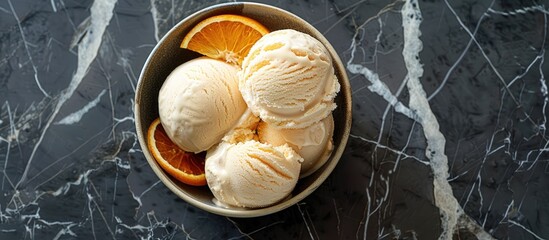 Poster - Orange citrus ice cream in a bowl on a stone backdrop with room for text or other elements in the image A chilled treat for the summer viewed from above in a flat lay composition