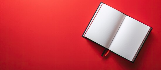 Poster - Top view of an open notebook on a red background laid flat with ample copy space image