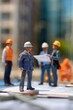 © grey - A mini figure businessman at a construction site, wearing a hard hat and discussing blueprints with engineers