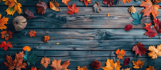 Poster - Flat lay view of a fall themed backdrop with an assortment of vibrant autumn leaves on weathered wooden planks ideal for adding text in the copy space image