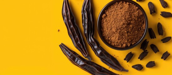 Poster - Top view of carob bean and powder on a yellow or brown background with copy space image