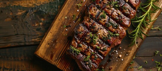 Poster - Top down view of a wooden board showcasing a spiced and herbed grilled beef steak ideal for a copy space image