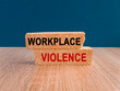 © Liudmila - Concept red words WORKPLACE VIOLENCE on brick blocks. Beautiful blue background, wooden table. Business concept.