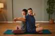 © Stockphotodirectors - Couple practicing partner yoga pose in home living room