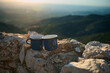 © Taras Grebinets - Two blue enamel coffee cups on rocky mountain top with scenic sunrise view