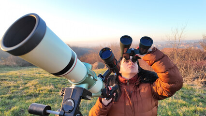 Wall Mural - Amateur astronomer observing skies with a telescope and binoculars.