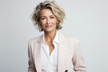 Poster - Portrait of a glad woman in her 50s dressed in a stylish blazer isolated on white background