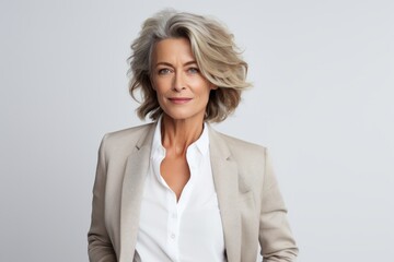 Poster - Portrait of a glad woman in her 50s dressed in a stylish blazer over white background