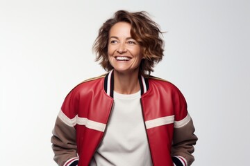 Poster - Portrait of a happy woman in her 50s sporting a stylish varsity jacket while standing against white background