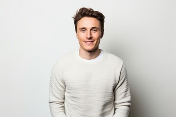 Poster - Portrait of a satisfied man in his 20s dressed in a warm wool sweater over white background