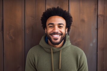 Sticker - Portrait of a grinning afro-american man in his 30s dressed in a comfy fleece pullover in front of rustic wooden wall