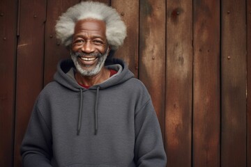 Poster - Portrait of a grinning afro-american man in his 70s dressed in a comfy fleece pullover while standing against rustic wooden wall