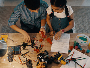 Above, children and siblings with robotic toy, building or assembling for bonding, together and home. Girl, boy and teamwork for creativity, playful and learning with tools, parts and manual in house