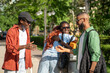 © DimaBerlin - Joyous hello of african american friends on street. Happy group of black students with good mood embrace each other as meet to spend time together.Two guys shake hands, girls smile hug, see each other