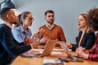 © .shock - In the vibrant ambiance of a modern startup office, a diverse team of business professionals engage in discussions on various projects and develop new business strategies, epitomizing creativity and