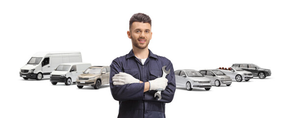 Wall Mural - Auto mechanic holding a wrench and posing in front of vehicles